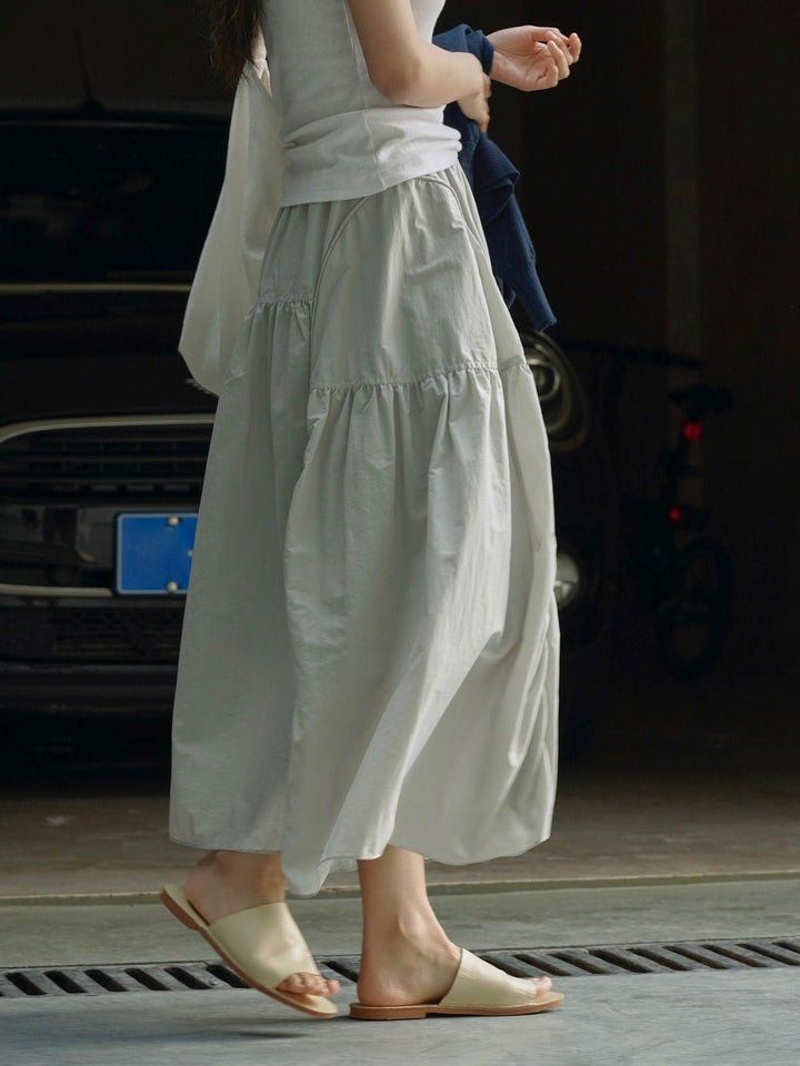 Stylish woman wearing a summer elastic waist, lightweight and breathable half length long skirt for women in gray.